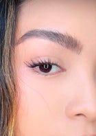 Woman applying ONYX Lash Australia cluster lashes in Socialite