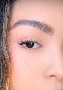 Woman applying ONYX Lash Australia cluster lashes in Socialite